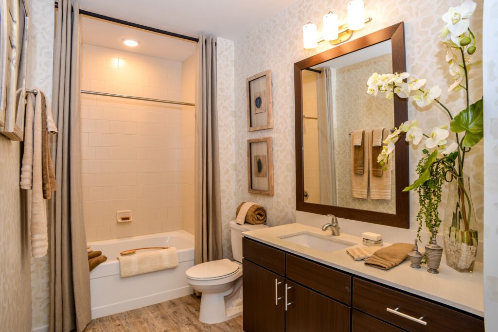 Bathroom with large mirror, marble countertop, and bathtub.