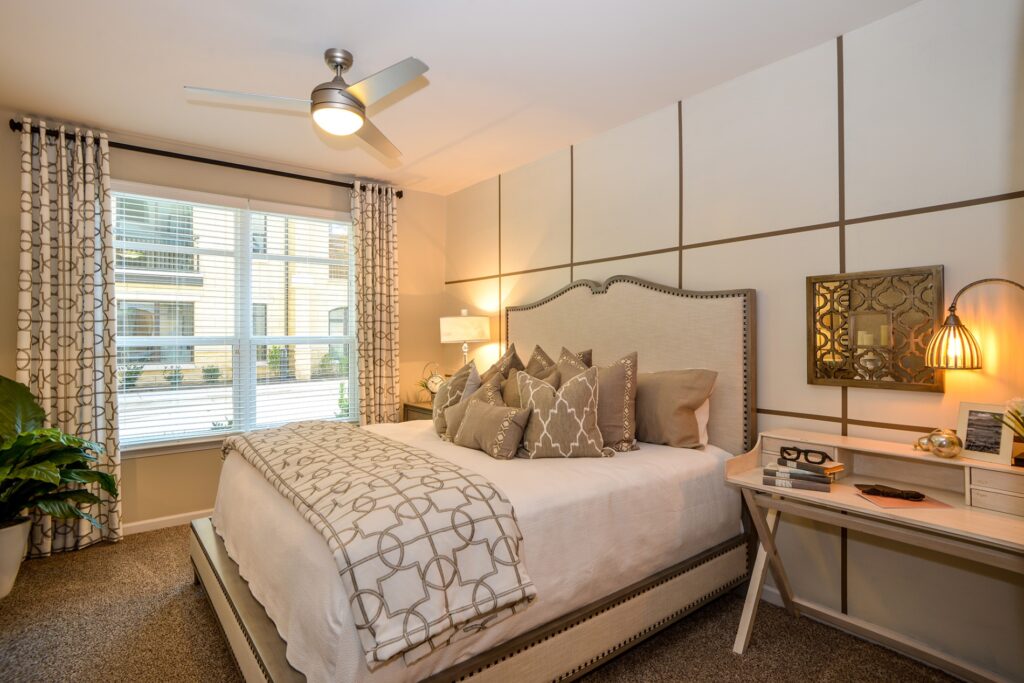 Bedroom with accent wall, large window, and carpet floors.