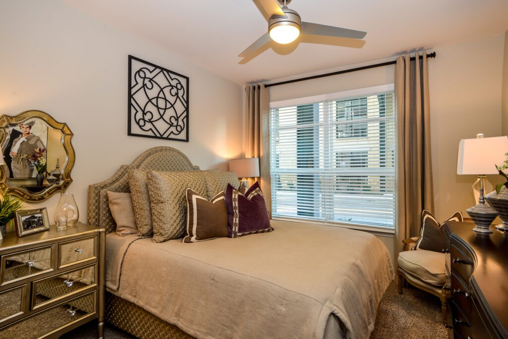 Bedroom with ceiling fan, large window, and carpet floors