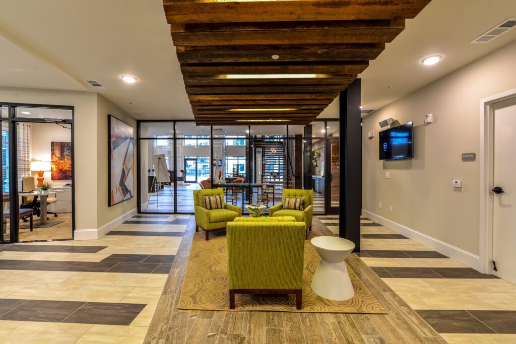 Leasing office sitting area with chairs and views of employee offices.