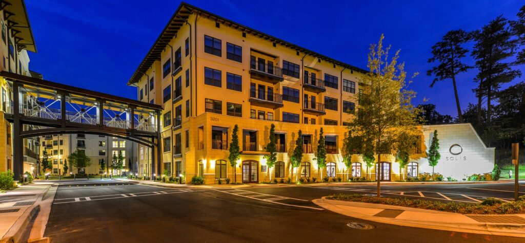 Night view of residential building with sky bridge and drive way underneath