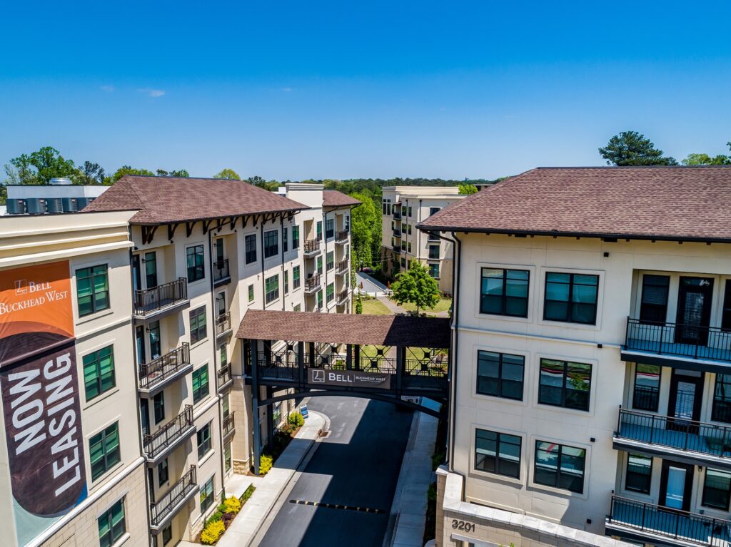 Bell buckhead west now leasing sign off side of residential building with sky bridge connecting to other residential building