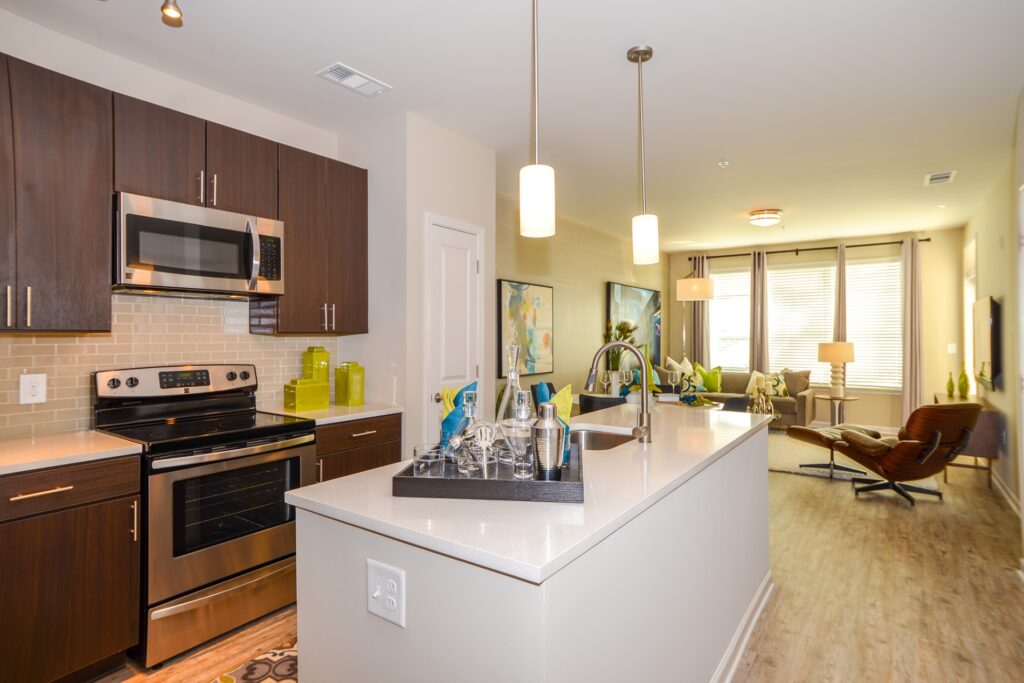 Kitchen island with granite counter tops, stainless steel appliances, and view of dining / living area in the back.