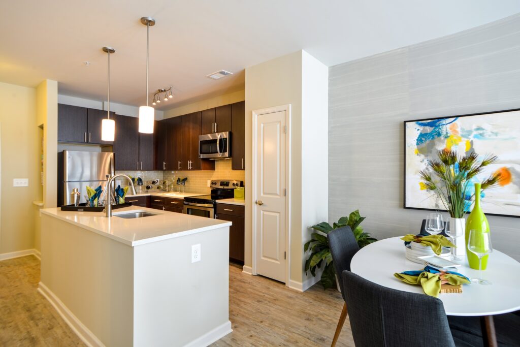 Kitchen island with granite counter tops, stainless steel appliances, and view of dining area.