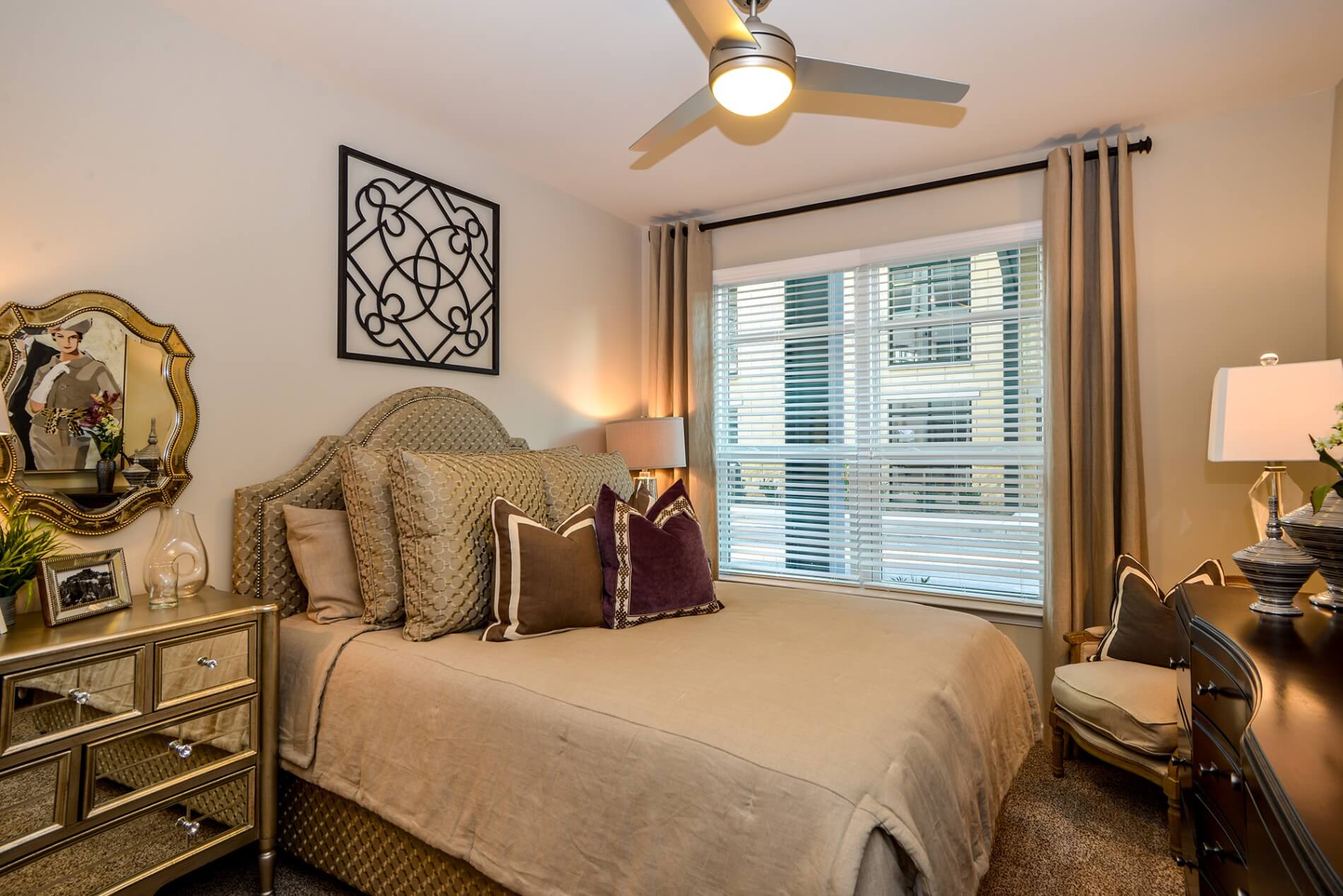 Carpeted bedroom with large window and ceiling fan